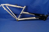 A Giant brand bicycle alloy frame for 26-inch wheels, featuring a silver color with some black components, displayed against a blue background.