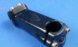 Black alloy bicycle handlebar stem with a 25.4 mm diameter handlebar clamp, viewed from the side against a blue background.